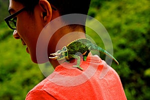 Boy with chameleon horned lizard in jungle